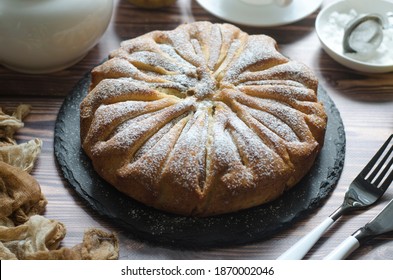 Pie with pears and powdered sugar on a board  