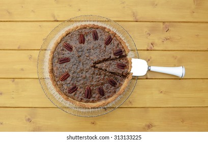 Pie server with cut slice in a traditional pecan pie on a glass plate