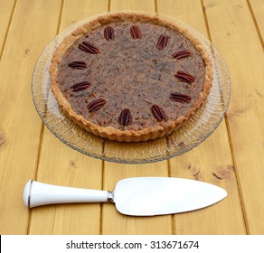 Pie server utensil with home-made pecan pie on a glass plate