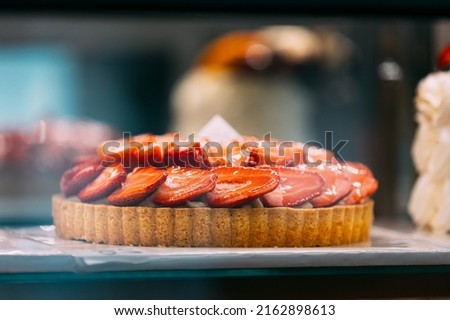 pie with strawberries, assortment baked pastry in bakery. Various Different Types Of Sweet Cakes In Pastry Shop Glass Display. Good Assortment Of Confectionery.