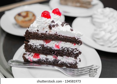 Piece Of A Black Forest Cake With Meringue And Egg Tart On The Background