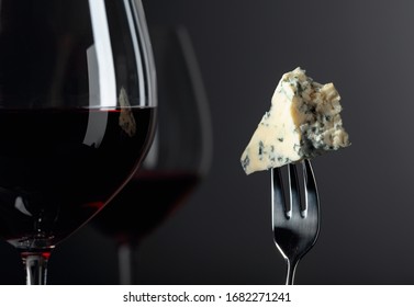 Piece Of Blue Cheese On A Fork And Red Wine. Copy Space.