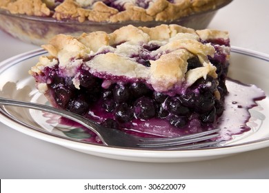 A piece of blueberry pie on a plate.