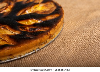 Piece Of Cake. Failed Apple Pie. Burnt On Top And The Dough Did Not Rise During Baking. Textured Burnt Pie Crust. Lies On Linen