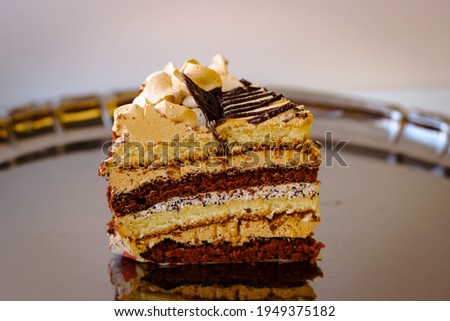A piece of cake with oil cream stands on a metal tray. The photo is slightly blurred Stock foto © 
