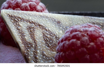 A piece of cake with raspberry and leaf of chocolate. Macro photography