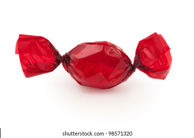 A  Piece Of Candy Or A Cough Drop Wrapped In Bright Red Cellophane Wrapper On A White Background