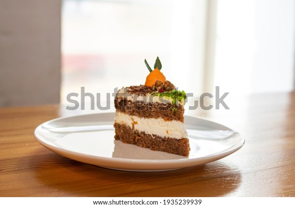 Piece of\
carrot cake on a plate on a wooden\
table