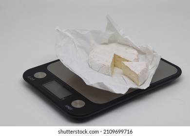 A Piece Of Cheese On The Scales. Weight Loss, Diet And Weight Control. Still Life With Healthy Food And Scales. Healthy Food. The Concept Of A Healthy Lifestyle. Weight Control During Self Isolation