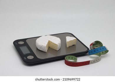 A Piece Of Cheese On The Scales. Weight Loss, Diet And Weight Control. Still Life With Healthy Food And Scales. Healthy Food. The Concept Of A Healthy Lifestyle. Weight Control During Self Isolation