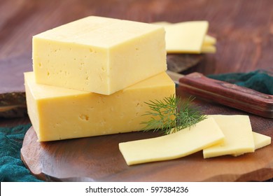 Piece of cheese on the wooden table.