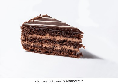 A piece of chocolate cake with cream on a white background.