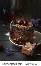 A Piece Of Chocolate Cake On A Fork Cut From A Bigger Slice. A Glasss Of Cherry Liquor On The Background. Selective Focus