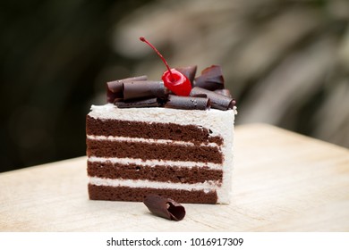 Piece Of Chocolate Cake With Vanilla Frosting And Cherry Jelly, Topped With White Cheese.