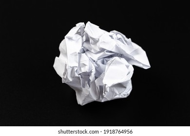 A piece of crumpled white paper on a black background.