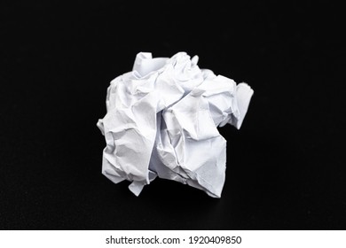 A piece of crumpled white paper on a black background.