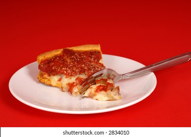 Piece Of Deep Dish Pizza On A White Plate, Red Background