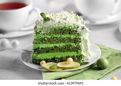 Piece of delicious creamy lime cake on saucer closeup