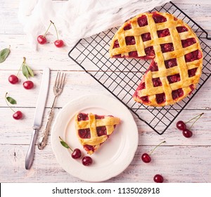 Piece of Delicious Homemade Cherry Pie with a Flaky Crust on rustic wooden white background