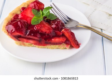 Piece of delicious homemade fresh strawberry  pie on a white plate.