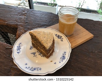 A Piece Of Earl Grey Creame Cake Served On A Small White Plate. A Glass Of Latte. High Angle View.