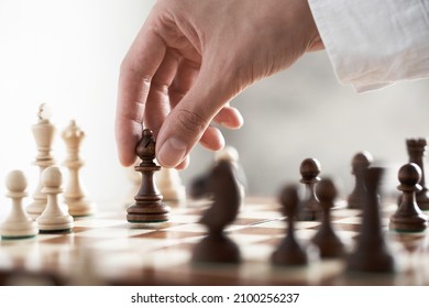 A piece for a game of chess officer an elephant makes a move soars in the air. The fingers of the hand are holding a chess piece. Chessboard cage rhombus tree in the air performing a move holds
 - Shutterstock ID 2100256237