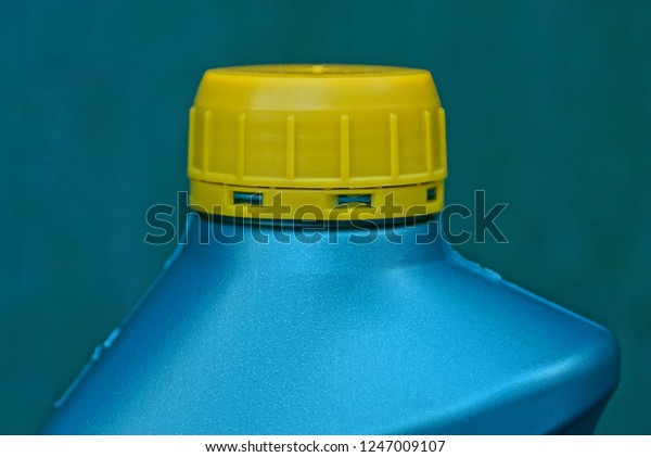 a piece of green plastic bottle closed with a yellow\
stopper with lube