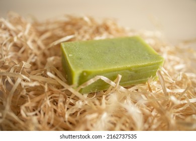 A Piece Of Green Soap Lies On Wrapping Paper, On A Wooden Table Surface. Hygiene, Soap Production, Supply Disruption, Shortages