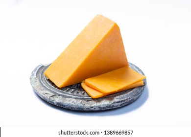 Piece Of Hard Orange Cheddar Cheese On Grey Stone Plate Isolated, Close Up