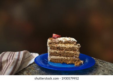 Piece Of Homemade Birthday Cake On The Blue Plate With Dark Background