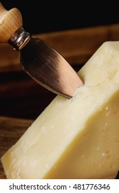 piece of Italian parmesan cheese with a knife.  wood background - Shutterstock ID 481776346