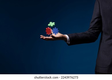 Piece of jigsaw puzzles floating over businessman hand, solutions, success and strategy concept. - Powered by Shutterstock