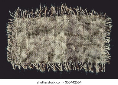 A Piece Of Linen Fabric With Frayed Edges On A Black Background