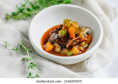 A piece of meat with stewed vegetables cut into cubes. Zucchini, pumpkin and potatoes. Snack in a small white bowl. ?opy space.