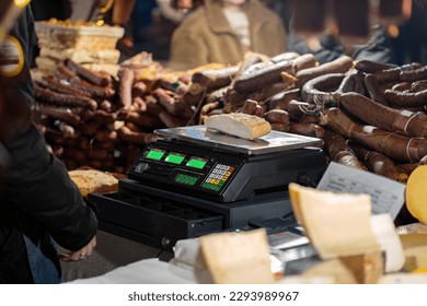 A piece of meat weighed on an electronic scale, traditional festive market stall detail, lots of different types of meat being sold, buying and selling natural organic food products, meat on sale - Powered by Shutterstock