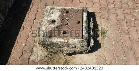 a piece of metal sitting on top of a sidewalk, blocked drains, aged armor plating, metal rust and plaster materials, ground up angle, metal towers and sewers, an armored core on the ground.