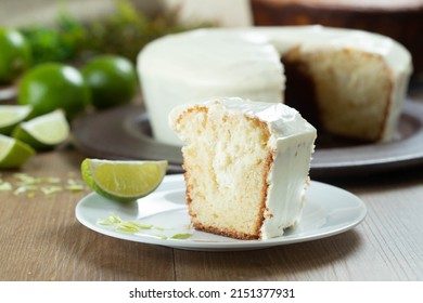 Piece of Moist lemon fruit cake on plate with lemon slices on wooden table. Delicious breakfast, traditional tea time. Lemon cake recipe.