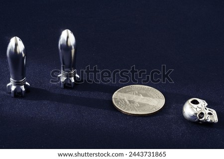 Piece of money, bullet, braincase on a black background. Metal objects. Scull, cranium, pericranium, coin. Rocket, pellet, ball, missile.                               