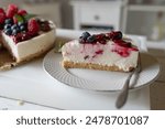 Piece of no bake cheesecake with berry topping on kitchen counter