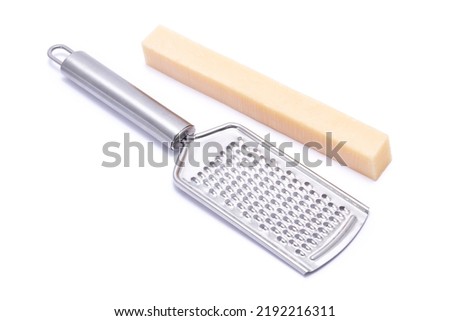 Piece of parmesan cheese and grater isolated on white background