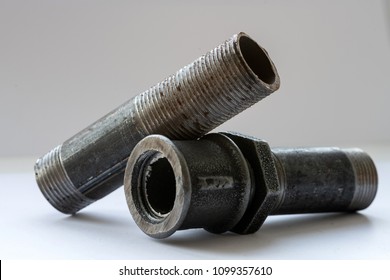 Piece of pipe with thread and nut. Plumbing tools. White background. Close up