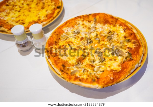 Piece of the pizza on wooden tray to\
divided pieces,Pizza is italian food with small bottle sault and\
pepper, the kind of food that fits into today\'s life\
style.