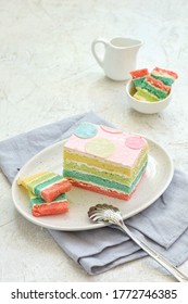a piece of rainbow cake with a colored layer, on an oval plate - Shutterstock ID 1772746385