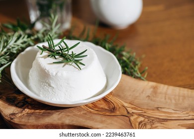 Piece of Ricotta cheese. Top italian cheeses - Ricotta Cheese. Ricotta cheese or cottage cheese with rosemary on white plate. - Shutterstock ID 2239463761