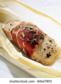 Piece of salmon wrapped in raw ham