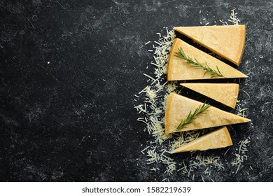 Piece of solid cheese on a black stone background. Parmesan. Top view. Free space for your text. - Powered by Shutterstock