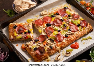 A Piece Of Square Pizza With Basil Pepperoni Tomatoes And Mushrooms On A Iron Tray