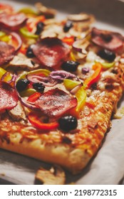 A Piece Of Square Pizza With Basil Pepperoni Tomatoes And Mushrooms On A Iron Tray