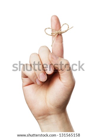 A Piece of string tied around man's index finger. Short depth of field, the sharpness is in the knot.