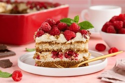 A Piece Of Tiramisu With Raspberries On A White Plate On The Table. Traditional Italian Dessert. Selective Focus